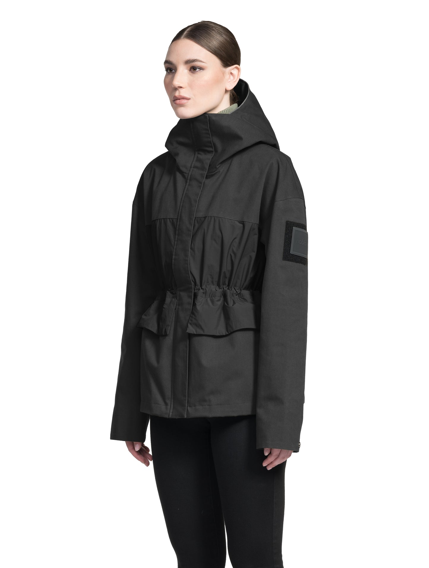 Opal Women's Performance Short Shell Jacket in hip length, premium cotton blend and contrast iridescent fabrication, adjustable drawcord at waist, non-removable hood with reflective trim, adjustable hood draw cord at interior collar, zippered side entry pockets at waist, top entry flap pockets at waist, adjustable snap cuffs, snap button wind flap, two-way branded zipper at centre front, and interior zipper pocket, in Black