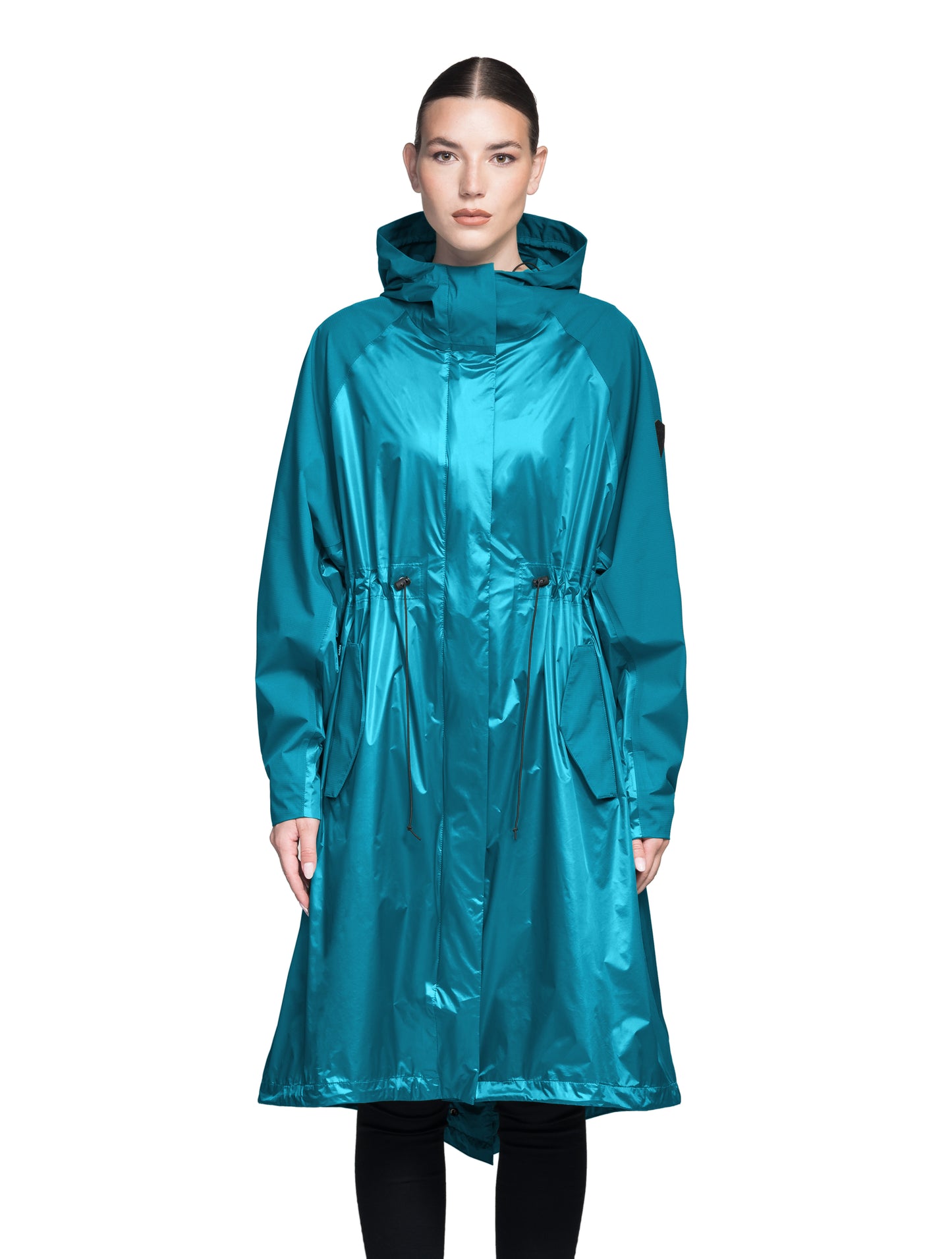 Reyna Women's Tailored Packable Long Shell Jacket in knee length, premium strech ripstop and contrast cire technical nylon taffeta fabrication, non-removable hood with adjustable draw cord, waist flap pockets with magnetic closures, adjustable draw cords at waist and bottom hem, adjustable snap cuffs, mesh back ventilation, hidden packable pocket, snap button wind flap, two-way branded zipper at centre front, adjustable snap button fishtail yoke at back, and large interior zipper pocket, in Deep Lake
