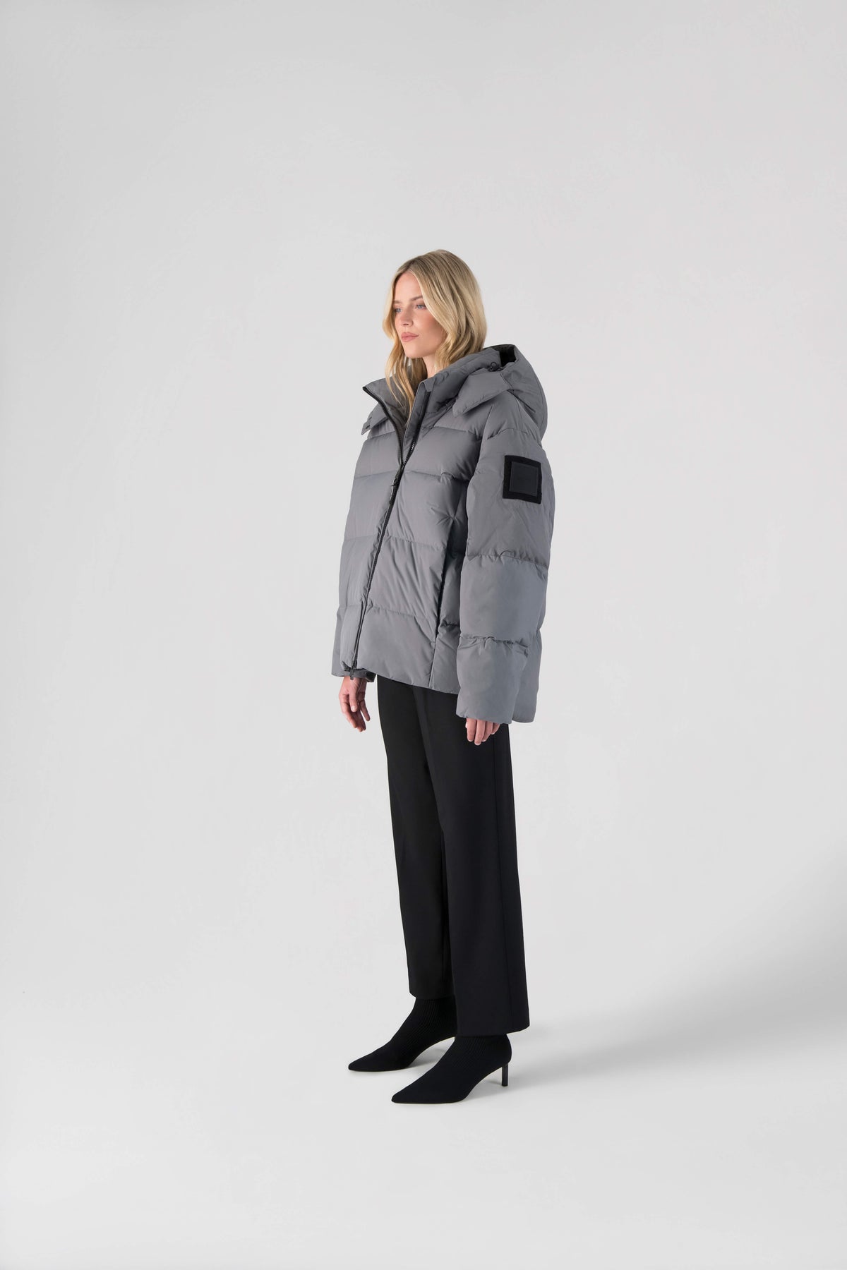 Una Ladies Performance Puffer in hip length, Technical Taffeta and Durable Stretch Ripstop fabrication, Premium Canadian White Duck Down insulation, removable down filled hood, centre front two-way zipper, and side-entry pockets at waist, in Concrete