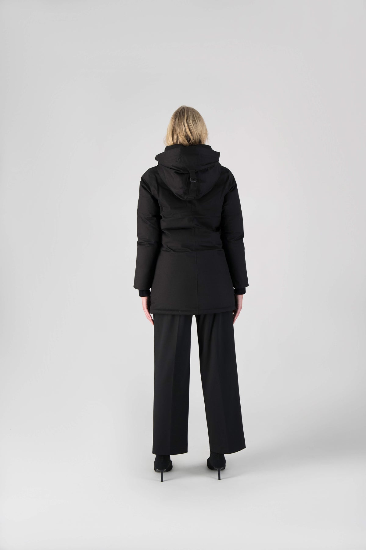 Women's down filled parka that sits just below the hip with a clean look and two hip patch pockets in Black