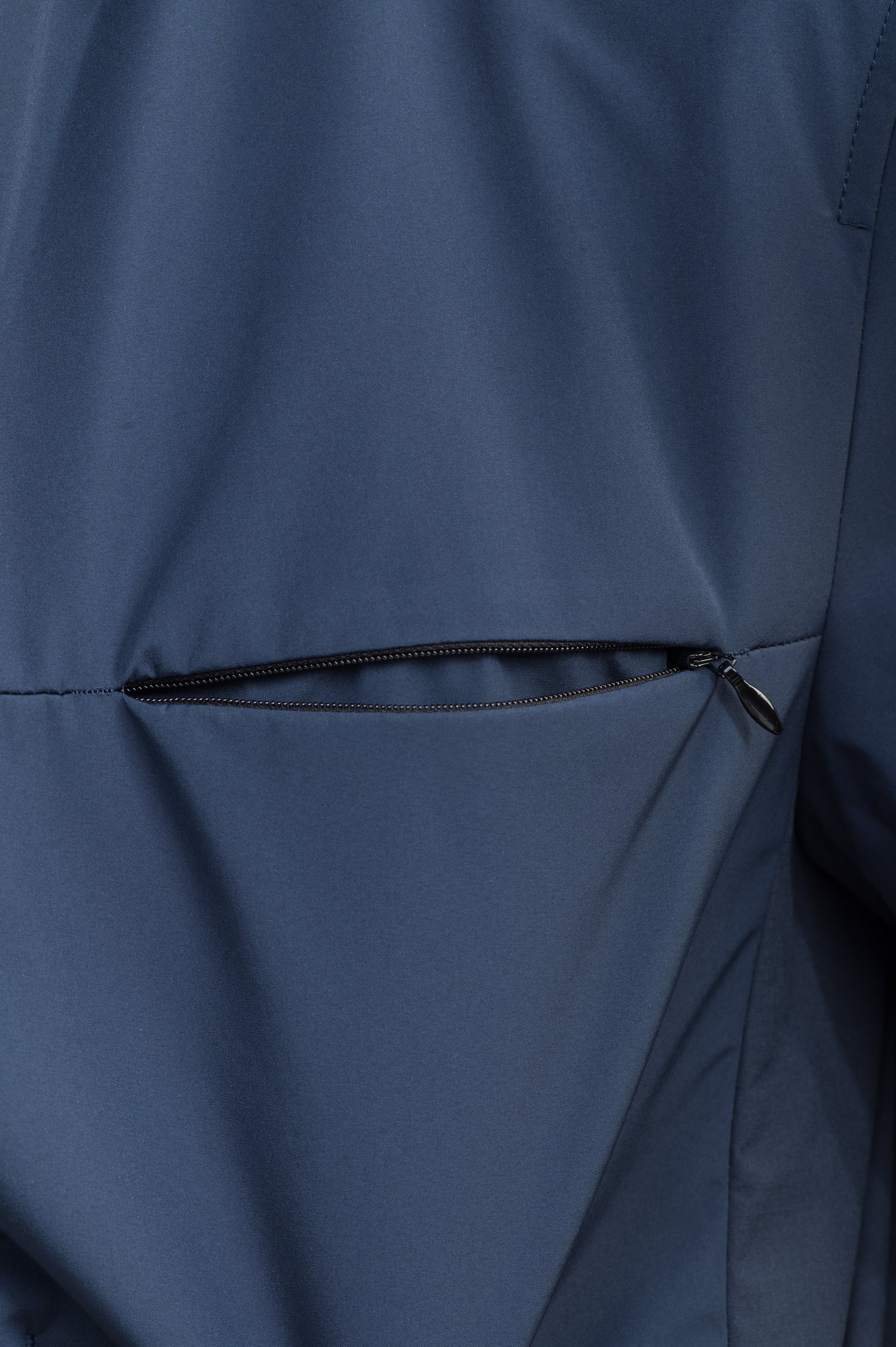 Cody Men's Tailored Travel Blazer in 3-ply micro denier and stretch nylon fabrication with DWR coating, Primaloft Gold Insulation Active+, hidden two-way zipper at centre front with snap closure placket, three invisible exterior zipper pockets, double back pleats, and hidden snap placket at cuffs, in Marine