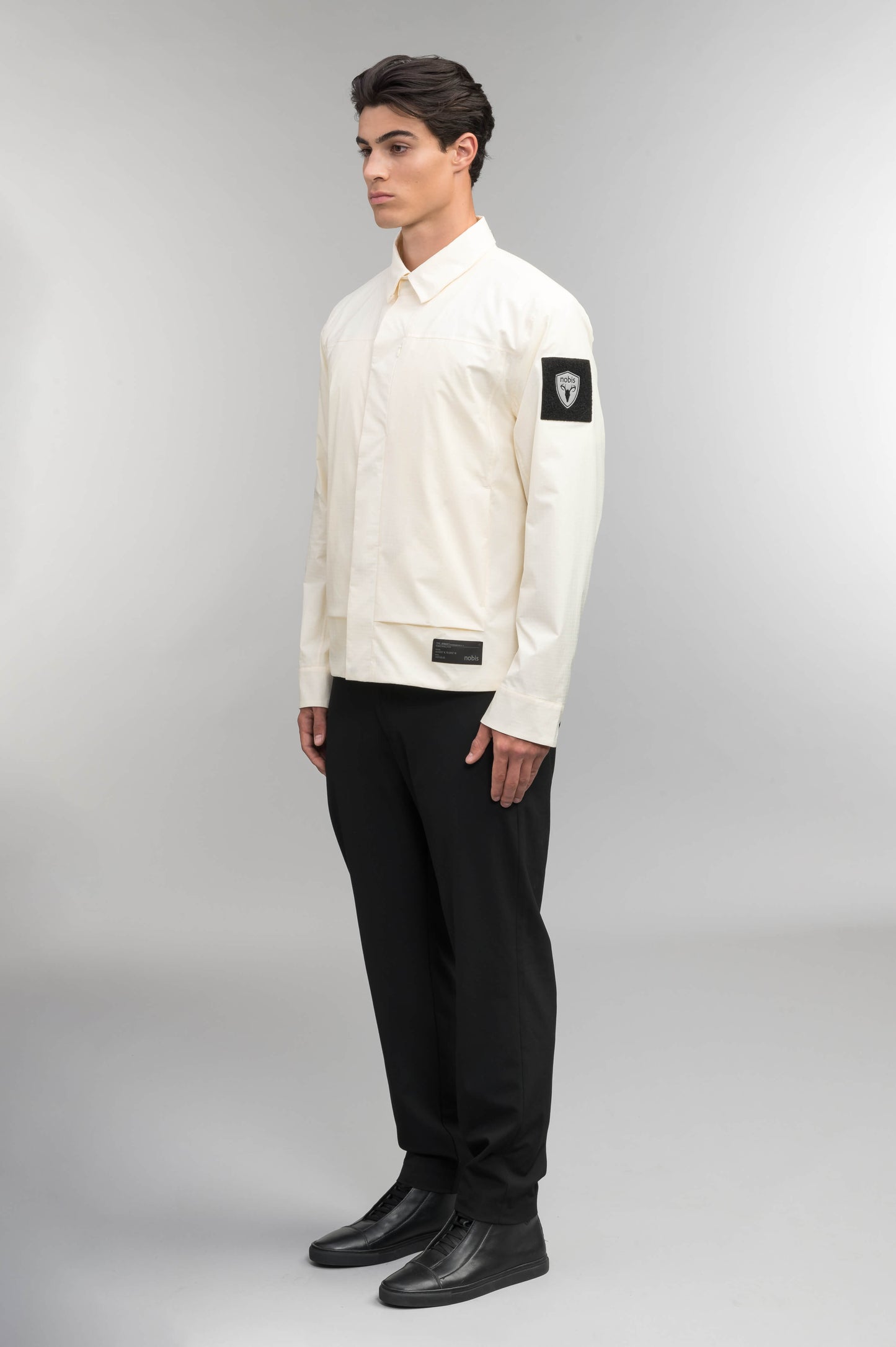 Farson Men's Waterproof Overshirt in Wheat made from premium recycled polyester ripstop with a DWR coating. Features a concealed snap-button front placket, adjustable snap cuffs, invisible chest zip pocket, dual zippered waist pockets, pit zip ventilation, and seam-sealed construction for enhanced weather protection. Designed in Canada.