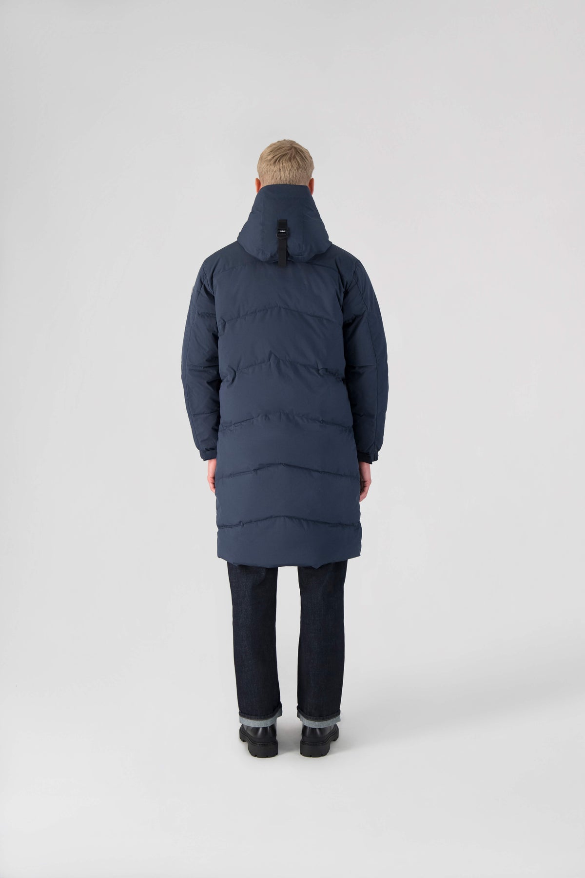 Granger long jacket in Marine stretch ripstop fabric with DWR coating, insulated with Canadian white duck down and Primaloft. Features a two-way zipper, magnetic closure, and adjustable cuffs for warmth and weather protection.