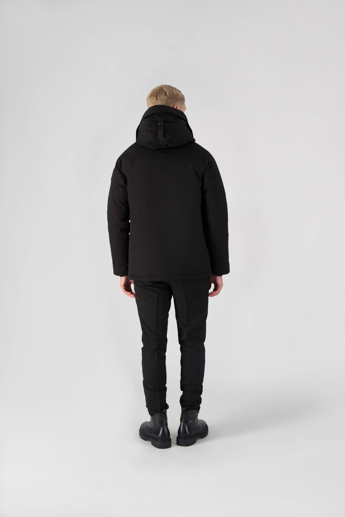 Men's waist length down filled jacket with two front pockets with magnetic closure and a removable fur trim on the hood in Black