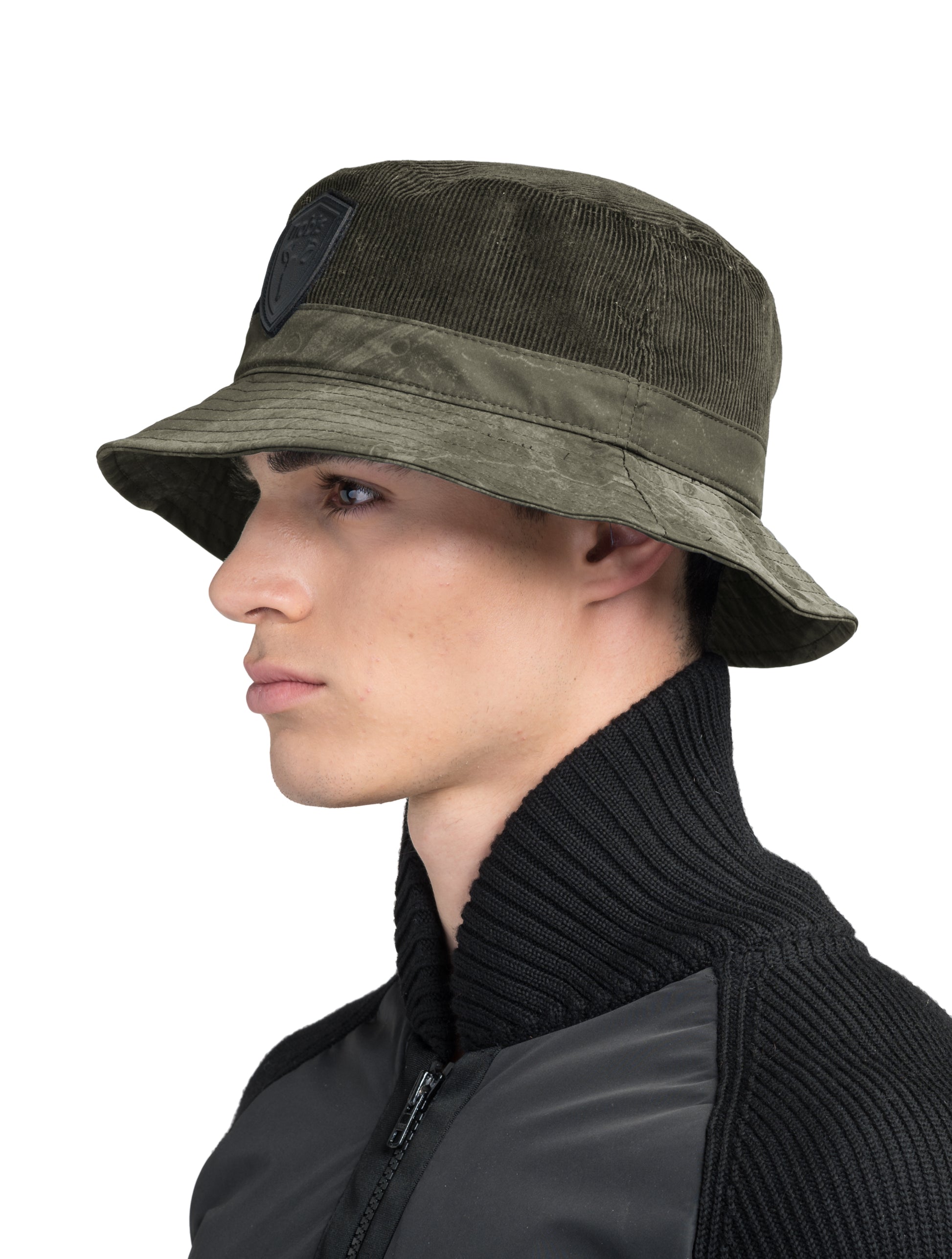 Kaia Unisex Tailored Bucket Hat in a 100% cotton corduroy and 3-ply micro denier fabrication, unstructured crown, black leather Nobis shield logo on crown front, and small flap pocket on the right side crown, in Fatigue