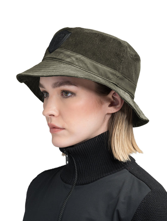 Kaia Unisex Tailored Bucket Hat in a 100% cotton corduroy and 3-ply micro denier fabrication, unstructured crown, black leather Nobis shield logo on crown front, and small flap pocket on the right side crown, in Fatigue + Fatigue