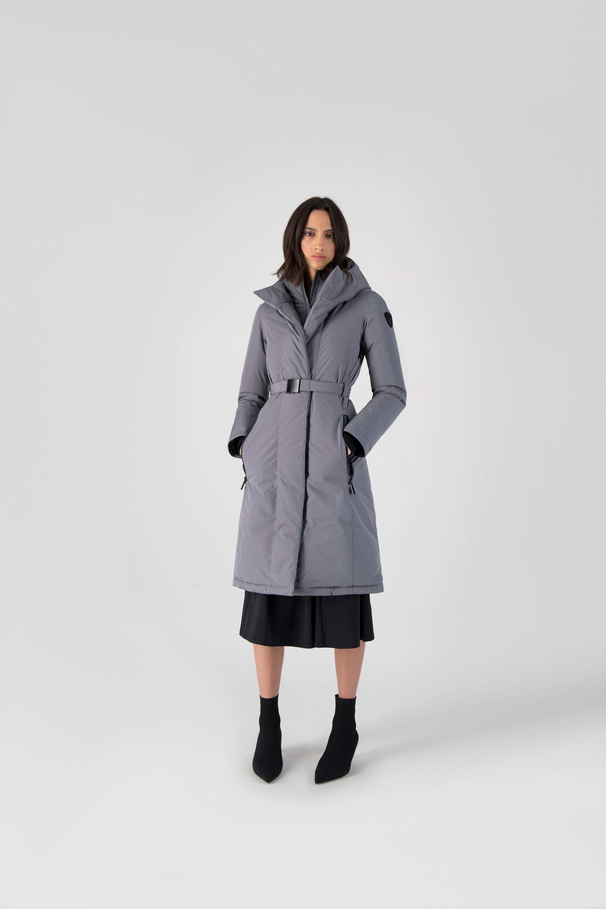 Long calf length hooded women's winter parka with an inner hip length closure, exterior hem length zipper and magentic placket in Concrete