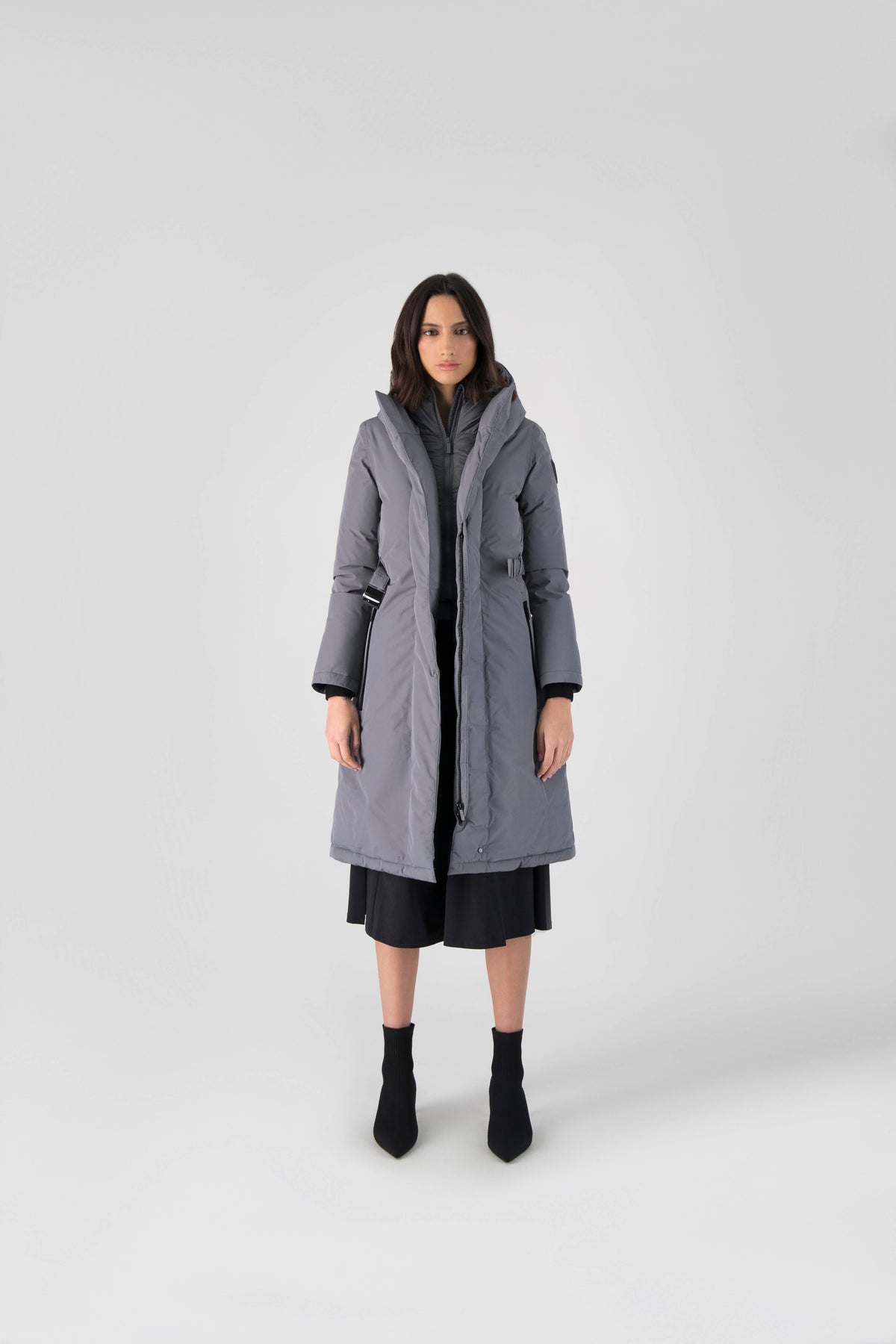 Long calf length hooded women's winter parka with an inner hip length closure, exterior hem length zipper and magentic placket in Concrete