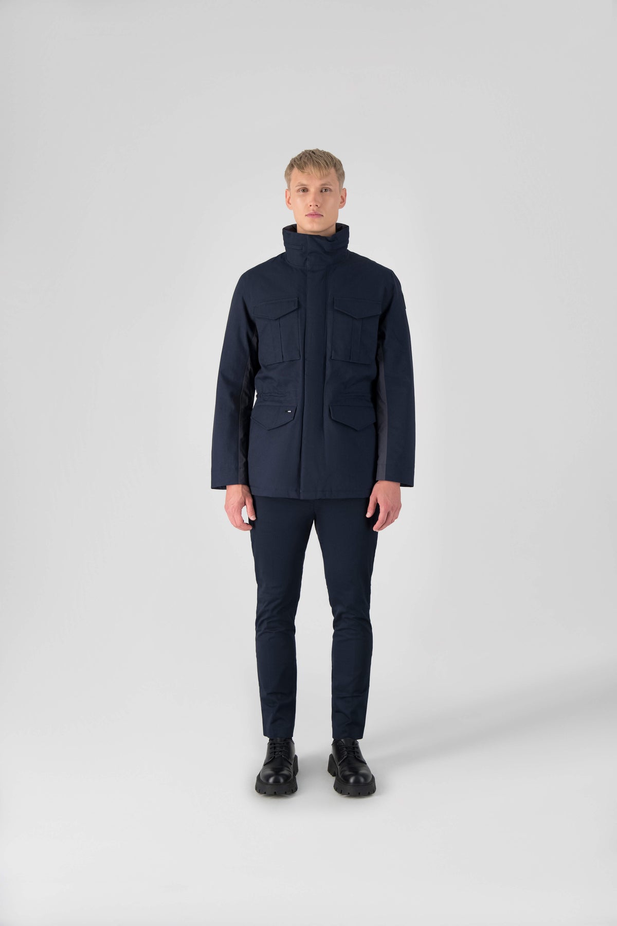 Pelican Men's Tailored Field Jacket in hip length, premium cotton blend and 3-ply micro denier fabrication, Premium Canadian origin White Duck Down insulation, tuck away, waterproof hood in premium cire technical nylon taffeta, two-way centre-front zipper with magnetic wind flap, pit zipper vents, magnetic closure chest and waist flap pockets, hidden adjustable waist drawcord, and action back detailing, in Navy