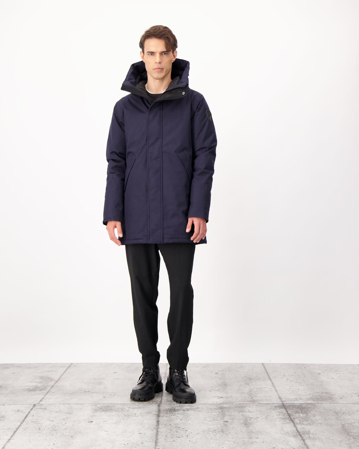 Pierre Men's Jacket in thigh length, Canadian white duck down insulation, non-removable down-filled hood, angled waist pockets, centre-front zipper with wind flap, and elastic ribbed cuffs, in CH Navy