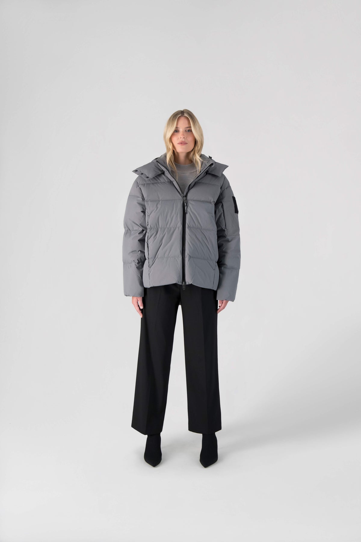 Una Ladies Performance Puffer in hip length, Technical Taffeta and Durable Stretch Ripstop fabrication, Premium Canadian White Duck Down insulation, removable down filled hood, centre front two-way zipper, and side-entry pockets at waist, in Concrete