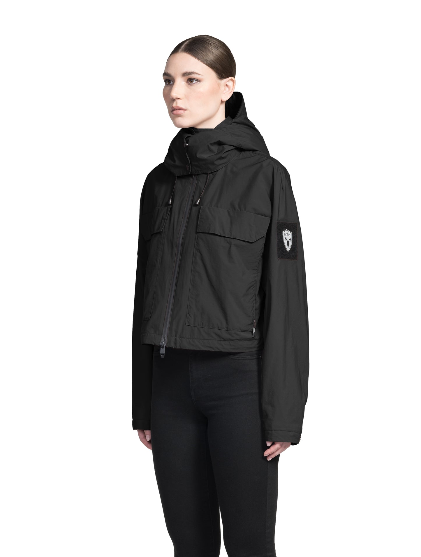 Viva Women's Performance Cropped Jacket in waist length, premium iridescent fabrication, removable hood with peak, adjustable hood draw cords and toggle, 2-way branded zipper at centre front, oversized magnetic closure flap pockets at chest with side entry, interior adjustable draw cord at hem, large interior zipper pocket, and adjustable snap cuffs, in Black