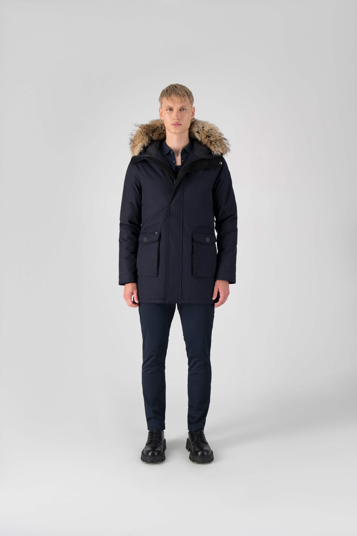 Men's slim fitting waist length parka with removable fur trim on the hood and two waist patch pockets in Navy