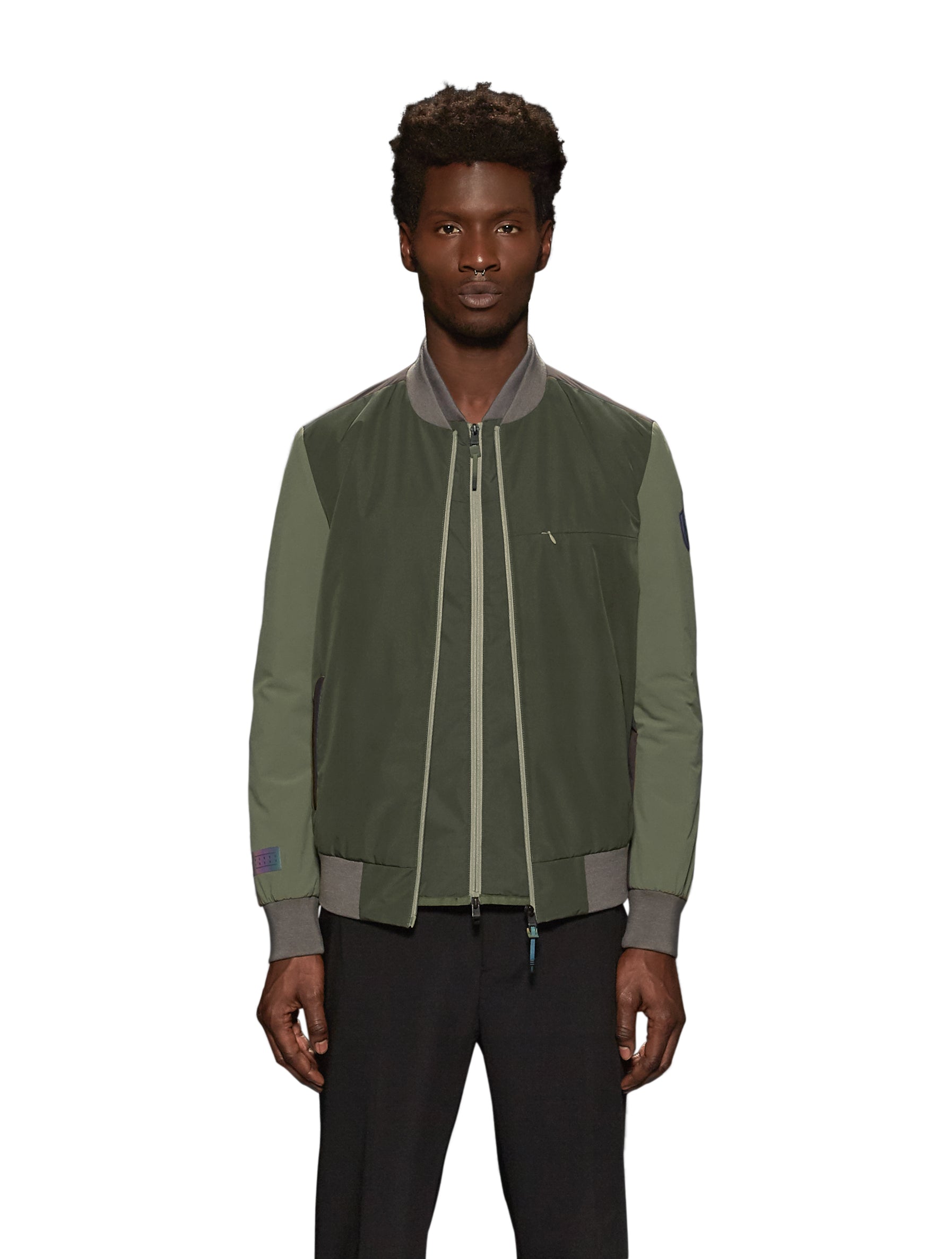 Unisex hip length bomber jacket with a contrast colour back panel, and zipper pockets at waist and an invisible zipper pocket at chest, in Dusty Olive/Licorice