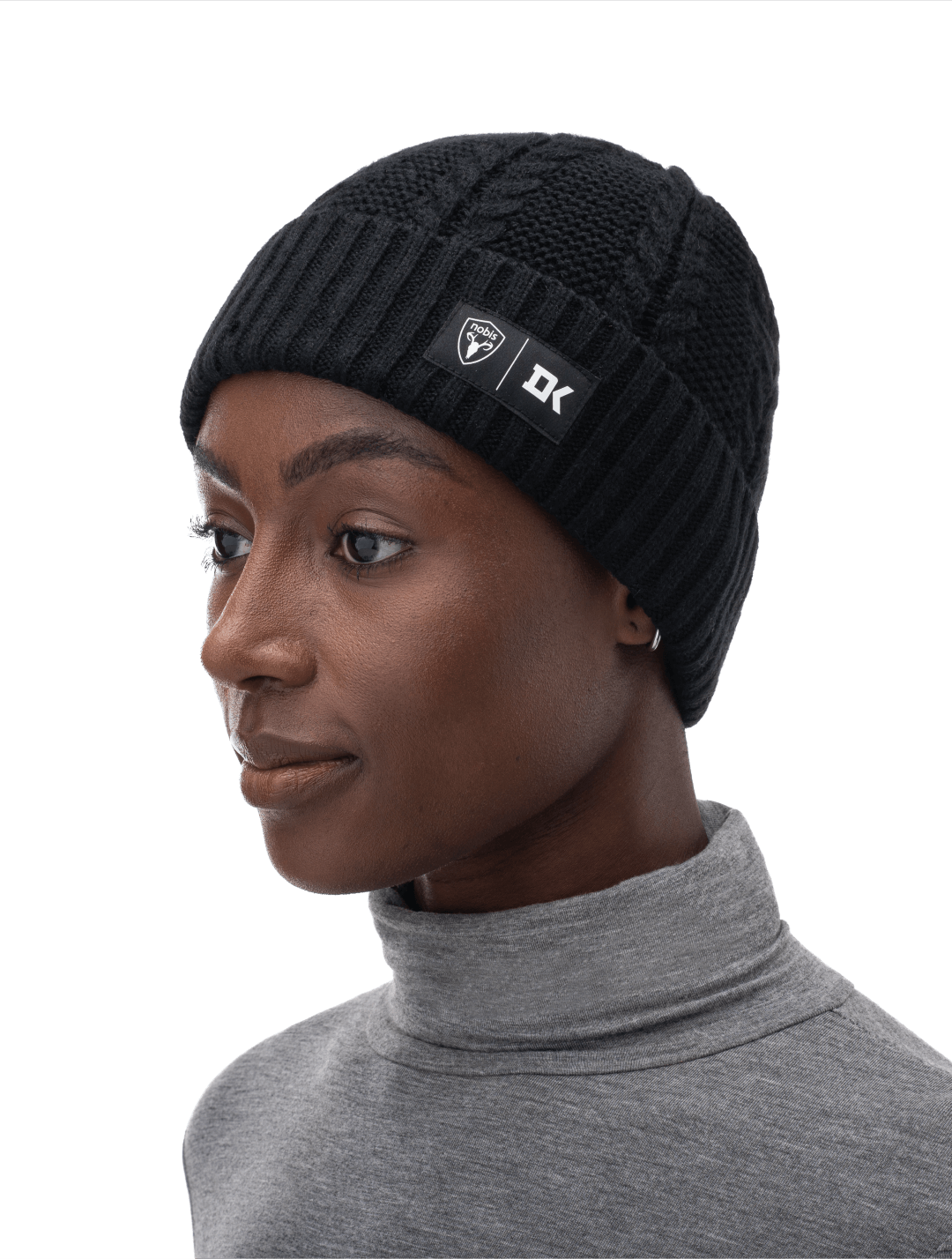 Duncan Keith x Nobis Unisex Cable Knit Beanie with cable stitched crown, two by two rib knit cuff, with co-branding label that features Keith's initials on cuff, in Black