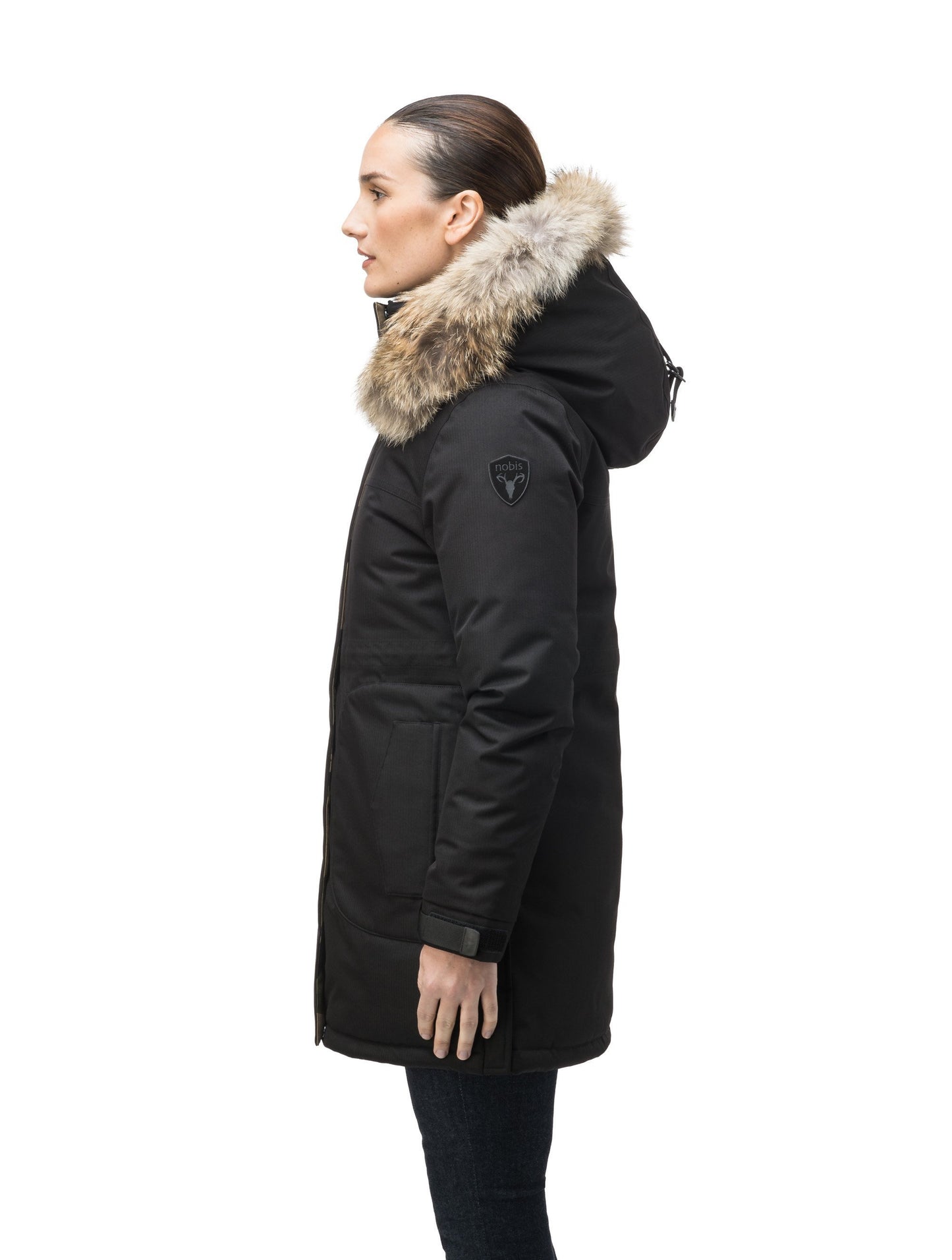 Thigh length women's down filled parka with side entry pockets and drawcord waist, removable hood and fur trim in Black